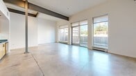 This 850 square foot urban loft, located in the heart of Sacramento, offers a contemporary living experience with its open-plan design and industrial-chic aesthetic. The space is characterized by polished concrete floors throughout, lending a modern and low-maintenance appeal. Large windows dominate one wall, flooding the area with natural light and providing panoramic views of the cityscape.

The main living area is spacious and versatile, with high ceilings and exposed structural elements that add to the loft's industrial charm. A sleek kitchen occupies one corner, featuring stainless steel appliances, wooden cabinetry, and a compact layout that maximizes functionality without compromising style.

The bathroom is a testament to modern design, with a glass-enclosed shower, neutral tiling, and a wooden vanity that adds warmth to the space. The loft's layout includes two hallway areas, likely leading to additional storage or utility spaces.

Despite its urban setting, the loft maintains a sense of tranquility through its minimalist design and neutral color palette. The combination of raw industrial elements with refined finishes creates a unique and inviting atmosphere, perfect for those seeking a contemporary urban lifestyle in Sacramento's vibrant downtown area.