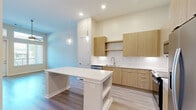 Located at 2828 Wicklow St in Savannah, Georgia, this thoughtfully designed one-bedroom, one-bathroom unit offers a clean, modern aesthetic across a single floor. Light-toned hardwood-style flooring flows seamlessly throughout the space, complementing the warm neutral palette of the walls and ceilings.

The kitchen serves as a central highlight, showcasing flat-front natural wood cabinetry, a striking herringbone-pattern tile backsplash, and a suite of stainless steel appliances including a refrigerator with ice maker, range, and microwave. A white-topped kitchen island with built-in shelving and pendant lighting overhead provides additional prep space and casual seating, making the kitchen both functional and stylish.

The living area is bright and airy, benefiting from tall ceilings, large windows with exterior views, and a ceiling fan that enhances comfort. The generously sized bedroom continues the bright, open feel, with multiple windows allowing abundant natural light and a ceiling fan for added airflow.

The bathroom features a lengthy dual-sink vanity with wood-toned cabinetry, white countertops, and lighted mirrors, offering ample storage and a clean, spa-like atmosphere. A dedicated walk-in closet with multi-tiered wire shelving and hanging rods provides excellent organization for storage needs.