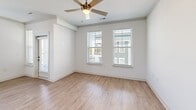 Located in Greenwood, Indiana, this thoughtfully designed single-floor home offers three bedrooms, two bathrooms, and a functional layout that balances comfort and style. The open-concept kitchen and living area serves as the heart of the home, featuring white shaker cabinetry with crown molding, quartz countertops, a gray subway tile backsplash, stainless steel appliances, and a large center island with pendant lighting — ideal for both cooking and casual dining. Light wood-look flooring flows throughout the main living spaces, adding warmth to the bright, white interior. The spacious living room includes crown molding and a ceiling fan, with large windows inviting abundant natural light. The generously sized primary bedroom connects to a private en-suite bathroom complete with a dual-sink vanity, quartz counters, dark hardware accents, wood-look flooring, and a glass-enclosed walk-in shower with marble-style tile surround. The secondary bedrooms are carpeted and feature ceiling fans and windows overlooking the exterior. A second full bathroom includes a tiled tub-shower combo with chrome fixtures. Additional highlights include a dedicated laundry room with a full-size washer and dryer and overhead shelving, plus two closets for ample storage throughout.
