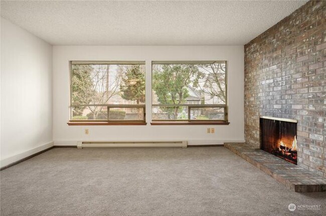 Large windows fill the unit with natural light and a view of the well-manicured yard outside. - 3033 21st Ave W