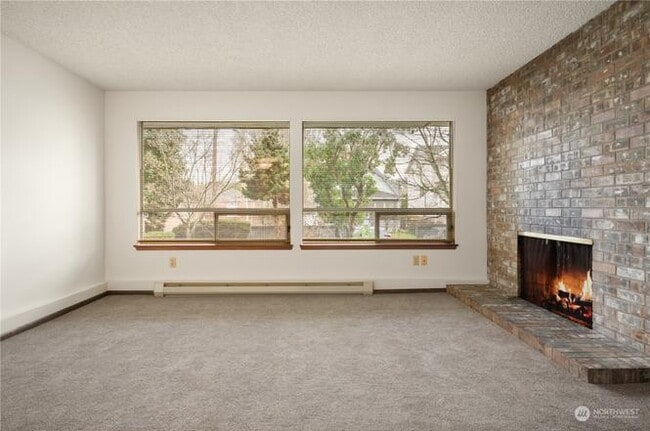 Large windows fill the unit with natural light and a view of the well-manicured yard outside. - 3033 21st Ave W