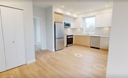 This contemporary 710 square foot apartment, located at 519-3600 Sexsmith Road in Richmond, offers a harmonious blend of style and functionality. The space comprises two bedrooms, two bathrooms, and an open-concept living area, all situated on a single floor. The primary bedroom, measuring 120 square feet, provides a comfortable retreat.

The kitchen is a standout feature, boasting sleek white and wood-toned cabinetry, stainless steel appliances including a built-in microwave, and a modern aesthetic. Large windows throughout the apartment flood the space with natural light, creating an airy ambiance. The living area seamlessly connects to a balcony via glass doors, extending the living space outdoors.

Both bedrooms feature light-colored walls and durable laminate flooring, with ample closet space. The bathrooms are outfitted with modern fixtures, including glass-enclosed showers and floating vanities. The overall design aesthetic is clean and minimalist, with a neutral color palette that allows for personalization.

The apartment's layout is efficient, with a central hallway connecting all rooms. Recessed lighting adds to the contemporary feel, while the large windows offer views of the surrounding urban landscape. This well-designed space combines comfort and style in a compact, urban setting.