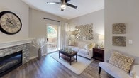 The Riesling is a thoughtfully designed single-floor, one-bedroom, one-bathroom residence that blends contemporary style with everyday comfort. The living area serves as the heart of the home, featuring warm wood-look flooring, a ceiling fan, and a striking stone-surround fireplace that anchors the room. A sliding glass door leads to a private patio, allowing natural light to fill the space and offering a seamless connection to the outdoors. The kitchen is outfitted with stainless steel appliances, grey shaker-style cabinetry, light quartz countertops, and a convenient breakfast bar peninsula — ideal for both cooking and casual dining. The bedroom is a serene retreat, showcasing a ceiling fan, multiple windows with natural light, and direct access to a spacious walk-in closet. The full bathroom features wood-look flooring, a tub-shower combination, and a clean, neutral palette throughout. A dedicated in-unit laundry closet with a full-size washer and dryer adds a practical touch rarely found in comparable residences. Neutral tones and consistent flooring throughout the home create a cohesive, modern aesthetic that is both inviting and functional.