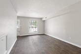 This two-story residence offers a practical and well-organized layout spread across two floors. The main level features durable wood-style flooring throughout the open living area, which is bathed in natural light from large windows fitted with blinds. The kitchen is efficiently designed with white cabinetry, ample counter space, and white appliances including a range and refrigerator. A dedicated dining area adjacent to the kitchen includes a windowed door providing additional natural light and exterior access.

Upstairs, both bedrooms are finished with soft carpeting and equipped with ceiling fans for year-round comfort. The primary bedroom offers a generous footprint with a closet, while the second bedroom also includes a closet and a window overlooking the outdoors. Each bedroom benefits from neutral wall tones that create a calm, versatile atmosphere.

The two bathrooms are clean and functional. The full bathroom features a tub-shower combination with tiled surround, a vanity with sink, and wood-style flooring, while the second bathroom is appointed with modern chrome fixtures. A dedicated closet provides additional storage. The home's straightforward design, consistent finishes, and ample natural light throughout make it a comfortable and efficient living space.