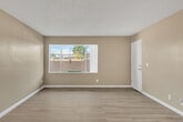 Located at 95 Hart Ln in Perris, California, this single-story 2-bedroom, 1-bathroom home offers a practical and well-organized layout. The open-concept living and kitchen area forms the heart of the home, featuring light wood-style laminate flooring and a textured ceiling with a ceiling fan. The kitchen is equipped with warm wood cabinetry, granite-style countertops, a gas range, and a double-basin sink, all illuminated by overhead panel lighting. A breakfast bar provides a seamless transition between the kitchen and living space.

The living room receives natural light through large sliding windows that offer views of the surrounding neighborhood. Both bedrooms are carpeted for comfort and feature windows that bring in ample daylight. The primary bedroom is generously sized and includes a sliding-door closet, while the second bedroom also benefits from dedicated closet space. Textured ceilings are consistent throughout both bedrooms.

The single full bathroom features a granite-style vanity countertop, white cabinetry, a mirrored medicine cabinet, and a combined shower and tub enclosure with clean white finishes and light wood-style flooring. The home's neutral color palette and functional layout make it a straightforward and comfortable living space.