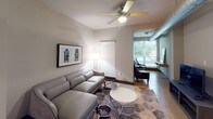 This 2-bedroom, 2-bathroom single-floor residence offers a practical and comfortable layout designed for everyday living. The kitchen serves as a functional hub, featuring stainless steel appliances including a French door refrigerator, electric range, and built-in microwave. Light wood cabinetry extends to the ceiling for ample storage, while dark granite countertops and a mosaic tile backsplash add visual interest. A kitchen island provides additional prep space, and light hardwood-style flooring runs throughout. A dedicated laundry area is conveniently accessible from the kitchen.

The living area is bright and welcoming, with a ceiling fan overhead and large windows fitted with horizontal blinds that allow natural light to filter in. The space connects to an adjacent area that provides flexibility for a home office or reading nook. Both bedrooms are carpeted and feature ceiling fans, large windows, and generous proportions. The primary bedroom includes access to a walk-in closet outfitted with wire shelving and multi-tiered basket storage. The bathrooms are finished with tile flooring, dark countertops, light wood cabinetry, and shower-tub combinations, maintaining a consistent, clean aesthetic throughout the residence.