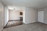 This two-floor residence offers a practical and well-organized layout designed for comfortable everyday living. The main level opens into a living area finished with plush carpeting and neutral wall tones, seamlessly transitioning to wood-look hard flooring in the kitchen and adjacent spaces. A staircase leads to the upper level, adding to the sense of verticality and flow throughout the home.

The kitchen is equipped with rich, dark cabinetry paired with light granite-style countertops, a stainless steel sink, and black appliances including a refrigerator and dishwasher. A textured ceiling is present throughout the space, adding subtle visual interest overhead.

The bedrooms are carpeted and feature windows fitted with blinds that allow natural light to filter in, as well as baseboard heating units along the walls. Each bedroom offers a quiet and comfortable retreat.

Two bathrooms serve the home — one featuring a single-sink vanity with dark cabinetry and a lighted mirror, and another equipped with a full shower-tub combination with brushed nickel fixtures. Both bathrooms continue the consistent use of dark wood-toned cabinetry and clean white fixtures.

A ceiling fan in the main living area and multiple vents throughout ensure year-round climate comfort. The cohesive design palette of warm neutrals and dark accents lends the space a clean, understated character.