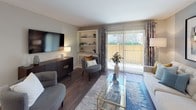 This single-floor residence offers a thoughtfully designed layout that balances comfort and functionality. The living room serves as the heart of the home, showcasing warm hardwood-style flooring, a built-in shelving unit with a fireplace, and sliding glass doors that open to a private balcony, filling the space with abundant natural light and outdoor views. A dedicated dining area sits adjacent to the living space, creating a seamless flow ideal for entertaining.

The kitchen is efficiently designed with crisp white cabinetry featuring brushed nickel hardware, granite-style countertops, and a black electric range with overhead ventilation. The clean, neutral palette keeps the space feeling bright and organized.

The bedroom is a serene retreat highlighted by a soft blue accent wall, plush carpeting, and a window that invites natural light. A walk-in closet provides generous storage, adding to the room's practicality and comfort.

The bathroom is finished with wood-style tile flooring, a white vanity with granite-style countertops, and a full tub-shower combination. A cohesive color palette of soft grays and blues runs throughout the residence, creating a calm and cohesive ambiance across every room.