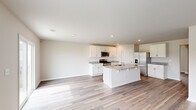 Located at 1157 Ridgeford Dr in Conway, South Carolina, this two-story home offers a well-designed layout across two floors, providing ample space for comfortable living. The main level features an open-concept kitchen and living area finished with light wood-look flooring that flows throughout the home. The kitchen is outfitted with white shaker-style cabinetry, granite countertops, a central island with a sink, and stainless steel appliances including a gas range, microwave, and refrigerator. Recessed lighting illuminates the space, enhancing the bright, airy ambiance. A separate living room offers additional flexible space on the main floor. The attached garage provides convenient vehicle storage with an automatic opener and concrete flooring. Upstairs, five generously sized bedrooms feature neutral-toned walls and wood-look flooring, with natural light provided by well-positioned windows. The spacious primary bedroom includes a walk-in closet with wire shelving for organized storage. Five full bathrooms are distributed across both floors, each featuring wood-look flooring and tub-shower combinations. A dedicated laundry room with a full-size washer and dryer and overhead wire shelving adds everyday convenience, rounding out this functional and move-in-ready home.