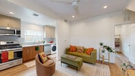 This 440 square foot home in Los Angeles maximizes space with a thoughtful layout and contemporary design. The living area boasts hardwood floors, recessed lighting, and a built-in shelving unit, creating an open and airy atmosphere. The kitchen showcases modern wood cabinetry, stainless steel appliances, and a convenient in-unit washer. A blue-toned bathroom features a sleek vanity and ample storage. The primary bedroom, measuring 130 square feet, offers a window for natural light and a warm color palette. A second bedroom provides additional living or work space. Throughout the home, white walls and strategic lighting enhance the sense of spaciousness. Clever storage solutions, including a walk-in closet with metal shelving, make the most of the compact footprint. The property's location at 121 S Avenue 63 in Los Angeles (90042) adds to its appeal, offering urban convenience in a stylish, efficient package.