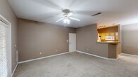 This single-story, one-bedroom, one-bathroom unit in Baton Rouge, Louisiana, offers a practical and cohesive layout across a compact but functional floor plan. The living room serves as the central gathering space, finished with neutral-toned carpet and warm taupe walls that carry consistently throughout the unit. A ceiling fan with integrated lighting provides both comfort and illumination. French doors along one wall allow natural light to filter in while providing exterior access. A pass-through counter connects the living area to the kitchen, enhancing the open feel between the two spaces.

The galley-style kitchen is efficiently organized with light wood cabinetry lining both walls, offering ample upper and lower storage. White appliances, including a refrigerator, range, and dishwasher, are provided. Wood-look flooring and track lighting overhead give the kitchen a bright, functional character.

The bedroom is a comfortable size, featuring carpet, a ceiling fan, and a window with blinds that brings in natural light. A walk-in closet provides generous storage. The full bathroom includes a single-sink vanity with wood cabinetry, a tub-shower combination with tile surround, and a large mirror.