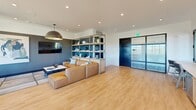 This contemporary 1080 square foot space in Charlotte, North Carolina, showcases a thoughtful blend of form and function. The interior is characterized by an open floor plan, maximizing the use of space and creating a seamless flow between areas. Large windows dominate the walls, flooding the space with natural light and offering panoramic views of the surrounding landscape.

The main living area features a sleek sectional sofa, complemented by a wall-mounted TV and a custom-built shelving unit that serves as both storage and room divider. The kitchen area boasts modern cabinetry, a functional island, and high-end appliances, all tied together with a subtle backsplash and warm wood flooring that runs throughout the space.

A standout feature is the inclusion of two outdoor terraces. One terrace is equipped with comfortable seating, perfect for casual gatherings, while the other offers a more intimate setting with plush outdoor furniture, ideal for relaxation or small gatherings. Both terraces are sheltered by wooden ceilings and provide unobstructed views of the area.

The space's design emphasizes a neutral color palette with occasional pops of color, creating a calm and inviting atmosphere. Recessed lighting and statement pendant lights add to the modern aesthetic while providing ample illumination. This versatile space seamlessly blends indoor and outdoor living, making it suitable for both entertaining and everyday relaxation.