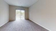 Located at 303 Mill Pond Ln in Salisbury, MD, this single-floor residence offers a clean, modern aesthetic throughout. The open living area features plush carpeting and neutral-toned walls, creating a bright and welcoming atmosphere. A pass-through kitchen counter with an integrated sink connects the living space to the kitchen, which is outfitted with white shaker-style cabinetry, light stone countertops, wood-look vinyl flooring, and stainless steel appliances including a refrigerator, range, and over-the-range microwave. Sliding glass doors in the living area invite natural light and provide outdoor access. The bedrooms are generously sized, each with soft carpeting, ceiling fans, and windows with blinds that offer views of the surrounding greenery. Two full bathrooms mirror each other in design, featuring white vanities with stone countertops, tile-surround soaking tubs with shower combinations, and wood-look vinyl flooring that complements the overall clean, contemporary style. The consistent neutral color palette and well-maintained finishes throughout give the space a move-in-ready appeal, ideal for comfortable everyday living.
