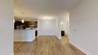 Located at 12509 Crown Park Ct in Charlotte, NC, this single-story residence offers a well-designed open-concept floor plan with a clean, contemporary aesthetic throughout. The living and dining areas flow seamlessly together, finished with warm wood-look flooring and crisp white walls that create a bright, welcoming atmosphere. A ceiling fan adds functionality to the main living space, which connects directly to the kitchen and provides views toward the bedrooms.

The kitchen is a standout feature, outfitted with rich dark espresso cabinetry, granite-style countertops, a classic white subway tile backsplash, and a full suite of stainless steel appliances including a refrigerator, range, and microwave. A peninsula with pendant lighting defines the kitchen's boundary with the living area, offering additional counter space and an open sightline across the unit.

The bedrooms are carpeted for comfort and receive ample natural light through large windows fitted with blinds, offering views of the surrounding neighborhood. The bathrooms are appointed with dark vanity cabinetry, granite-topped counters, large mirrors, and wood-look flooring, maintaining a consistent design language throughout the home.