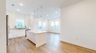 Located at 1 Riverside Ave in Jacksonville, FL, this well-appointed single-floor residence offers four bedrooms, two bathrooms, and a thoughtfully designed open-concept layout. The interior is characterized by a clean, modern aesthetic, with crisp white walls, recessed lighting, and warm light wood-style flooring that runs throughout the entire home.

The kitchen is a standout feature, showcasing sleek white flat-front cabinetry, a gray subway tile backsplash, quartz countertops, stainless steel appliances, and a central island with pendant globe lighting. It flows seamlessly into the combined dining and living area, which is bright and airy thanks to multiple large windows that invite abundant natural light.

The four bedrooms are well-proportioned, each featuring the same wood-style flooring and generous window coverage that provides views of the surrounding neighborhood. Each bedroom is served by a dedicated closet. The primary bedroom offers a comfortable footprint ideal for a full furniture arrangement.

The two bathrooms are finished in a modern style, featuring white vanities with undermount sinks, large mirrors, and glass-enclosed showers with tile surrounds. A dedicated laundry room and two hallways complete the functional layout. The home's entrance provides a welcoming transition into the main living spaces.
