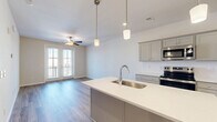 Located at 201 Munn Road in Nashville, TN, this well-appointed 1-bedroom, 1-bathroom residence offers a thoughtfully designed single-floor layout. The open-concept living area seamlessly connects the kitchen, dining, and living spaces, creating a bright and functional environment. Hardwood-style flooring runs throughout the main living areas, complemented by a ceiling fan and French doors that open to a private balcony, filling the space with natural light and outdoor views.

The kitchen is a standout feature, showcasing gray shaker-style cabinetry, white quartz countertops, a subway tile backsplash, and a full suite of stainless steel appliances including a refrigerator, electric range, and microwave. A peninsula island with an undermount sink and pendant lighting adds both style and practicality, ideal for casual dining or entertaining.

The bedroom is a comfortable retreat, carpeted for warmth, with a ceiling fan, multiple windows offering natural light, and access to a spacious closet with wire shelving. The bathroom features a white quartz vanity, a full tub-shower combo, and wood-look tile flooring. Additional spaces include a laundry area, pantry, utility room, and multiple closets for generous storage throughout.