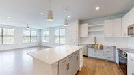This single-story, 2-bedroom, 2-bathroom home on Nexus Ave in Stafford, TX offers a thoughtfully designed open-concept layout with modern finishes throughout. The kitchen serves as the heart of the home, showcasing white shaker-style cabinetry, a subway tile backsplash, quartz countertops, a large center island with pendant lighting, a stainless steel farmhouse sink, and a full suite of stainless steel appliances. The kitchen flows seamlessly into a bright living area illuminated by multiple windows offering outdoor views, complemented by light wood-tone flooring and a ceiling fan. The primary bedroom features plush carpeting, a ceiling fan, a walk-in closet with built-in shelving, and direct access to an en-suite bathroom with a quartz vanity and an LED-backlit mirror. The second bedroom also offers carpeted floors, a ceiling fan, and a window with outdoor views. A dedicated laundry area houses a stacked washer and dryer alongside a cabinet with a built-in countertop. Clean white walls, recessed lighting, and consistent modern hardware unify the home's crisp, contemporary aesthetic throughout.