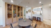 Located at 1400 Midvale Ave in the desirable Westwood neighborhood of Los Angeles, this single-floor residence offers a thoughtfully designed layout with a warm and inviting ambiance throughout. The open-concept living and dining area serves as the heart of the home, anchored by rich hardwood-style flooring and recessed lighting. A built-in wood and glass display cabinet adds a distinctive architectural touch to the dining space, which comfortably accommodates a round dining table. The living room features a fireplace, a sliding glass door that opens to an outdoor view of the cityscape, and ample natural light streaming in — creating a bright and airy atmosphere. Adjacent to the dining area, the kitchen is efficiently designed with white cabinetry, quartz countertops, stainless steel gas range, dishwasher, and a pass-through window that maintains a connected feel to the living spaces. The bedrooms are carpeted and well-proportioned, with one featuring a mirrored sliding-door closet with built-in shelving. Two bathrooms serve the residence — one with a vanity, large mirror, and walk-in shower, and another with a shower-tub combination — both finished with neutral tile flooring. Overall, the space presents a clean, functional, and comfortable living environment in a prime Los Angeles location.