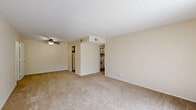 This two-bedroom, two-bathroom apartment in Lyndon, Kentucky, offers a well-organized single-floor layout designed for comfortable everyday living. The living room is generously proportioned, featuring neutral-toned carpet, a ceiling fan with light fixture, and a sliding glass door that fills the space with natural light and provides access to an outdoor view. A front entry door with a panel design opens directly into this welcoming area.

The kitchen is efficiently arranged with wood-trimmed white cabinetry offering abundant storage, light-toned laminate countertops, a double-basin sink, and white appliances including a refrigerator, electric range, and dishwasher. Hardwood-style flooring adds a clean, practical finish to this space.

The primary bedroom is notably spacious and includes a wide bifold closet, carpeted flooring, and access to the hallway. The second bedroom is bright and airy, benefiting from a window with an outdoor view and soft carpeting. Both bathrooms are cleanly appointed with tub-shower combinations, tile flooring, and vanity storage. A dedicated utility room and two closets round out the storage options throughout. The overall palette of warm neutrals and white trim creates a clean, move-in-ready atmosphere throughout the home.
