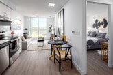 Located at 5 Zappacosta Drive in Toronto, this thoughtfully designed one-bedroom, one-bathroom unit offers a bright and efficient open-concept layout finished with light hardwood-style flooring throughout. The combined kitchen and living area serves as the heart of the unit, where a sleek, modern kitchen features white flat-panel cabinetry, stainless steel appliances including a refrigerator, electric range, and dishwasher, along with a clean white countertop and subway tile backsplash. The living and dining area flows seamlessly from the kitchen, benefiting from generous natural light streaming through large floor-to-ceiling windows that frame open city views. The bedroom is a well-proportioned retreat, also featuring a large window with an outdoor view and access to a private balcony, allowing abundant natural light to fill the space. A dedicated closet provides practical storage. The four-piece bathroom is finished with warm neutral tones, white cabinetry, a single vanity with a sink, and a full soaking tub with a shower. Throughout the unit, crisp white walls and light flooring create a clean, contemporary ambiance that feels airy and welcoming — an ideal urban residence in Toronto's northwest.