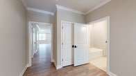 This single-floor home showcases a cohesive, modern design with clean lines and a neutral color palette throughout. Wide-plank wood-look flooring flows seamlessly across the main living and bedroom areas, complemented by crisp white trim, crown molding, and soft gray walls that create a bright, welcoming ambiance.

The open-concept kitchen and living area serves as the heart of the home, featuring light wood cabinetry with matte black hardware, quartz countertops, stainless steel appliances, and a tasteful herringbone tile backsplash. The generous layout allows for comfortable dining and lounging in a single connected space.

The hallway leads to multiple well-proportioned bedrooms, each offering natural light through large windows with blinds and ample room to accommodate various furnishings. Crown molding details carry throughout, maintaining a polished aesthetic.

The bathroom is thoughtfully finished with large-format tile flooring, a soaking tub with tiled surround, a wood-toned vanity with white countertop, and matte black fixtures and accessories. A dedicated utility area provides additional cabinetry, a utility sink, and extra storage.

Completing this home is a spacious attached two-car garage with automatic opener, recessed lighting, and a clean concrete floor — offering both practicality and convenience.
