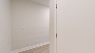 Located at 232 E 2nd St in the heart of downtown Los Angeles, this 2-bedroom, 2-bathroom unit delivers a practical and modern living experience across a thoughtfully designed single-floor layout. The open-concept living and kitchen area is anchored by light wood-style flooring that flows throughout, creating a bright and cohesive feel. A structural column adds an architectural touch to the spacious living room, which features a glass door for natural light. The kitchen is well-appointed with dark espresso cabinetry, a subway tile backsplash, stainless steel appliances including a gas range, microwave, dishwasher, and refrigerator, along with light countertops that complement the overall palette. Both bedrooms are carpeted and receive natural light through large windows with horizontal blinds — the primary bedroom features city views, while the secondary bedroom overlooks greenery. Each bathroom is finished with dark wood vanities, light countertops, a tub-shower combination, and wood-style flooring. A hallway connects the private areas of the unit, and ample door placements suggest generous closet storage. The overall ambiance is clean, contemporary, and move-in ready.