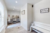 Located at 6075 Grelot Rd in Mobile, Alabama, this single-floor pet grooming facility is thoughtfully designed to provide a clean, functional, and welcoming environment for pets and their owners. The space is divided into two distinct zones: an active grooming area and a comfortable waiting area.

The grooming area is the centerpiece of the facility, featuring a large stainless steel pet wash tub equipped with a sprayer, safety restraint straps, built-in storage, and a non-slip step for easy pet access. A dedicated grooming table sits nearby, offering ample workspace for drying and styling. The back wall is finished with classic white subway tile accented by dark grout, lending a clean and professional aesthetic. Recessed lighting illuminates the space evenly, while a glass-panel exterior door allows natural light to filter in.

The waiting area offers a white bench for owners and is accented with charming pet-themed décor, including a dog-print wallpapered accent wall and a playful "Dog Kisses Fix Any Bad Day" sign. Posted wash rules and a waste station reinforce the facility's organized and hygienic approach. Throughout the space, large-format light tile flooring with floor drains ensures easy maintenance and cleanliness. The overall atmosphere is bright, tidy, and purpose-built for the comfort and care of pets.