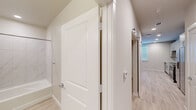 Located at 1610 Campbell Road in Houston, TX 77055, this single-floor unit offers a clean, modern aesthetic across its efficiently arranged layout. Light-toned, wood-look flooring flows consistently throughout every room, lending a cohesive and contemporary feel to the entire space.

The kitchen is well-appointed with granite-look countertops, crisp sage-toned cabinetry, a white subway tile backsplash, and stainless steel appliances including a range, microwave, and dishwasher. A single-basin undermount sink and a sleek faucet complete the functional workspace.

The bathroom features a tub-shower combination adorned with large-format marble-look tile surround, a granite-top vanity with matching cabinetry, recessed lighting, and a wall-mounted storage cabinet — offering a polished, spa-like finish.

The remaining rooms are bright and open, with neutral beige walls, recessed lighting, and ceiling fans that contribute to a comfortable, airy atmosphere. One room benefits from a window fitted with white blinds, allowing natural light to fill the space. An electrical panel is accessible within one of the rooms, adding practicality to the layout.

A connecting hallway with angled ceilings and panel-style doors ties the rooms together with clean architectural lines. Overall, this unit presents a well-finished, move-in ready space with modern details throughout.