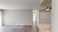 This well-designed single-floor home features 3 bedrooms, 2 bathrooms, and a thoughtful layout that maximizes functionality throughout. The open-concept living and dining area is highlighted by wide-plank hardwood-style flooring, neutral warm-gray walls, and a large sliding glass door fitted with vertical blinds that invites abundant natural light and outdoor views. A ceiling fan adds comfort to the adjacent space, which also features a double-door closet for added storage.

The kitchen is efficiently designed with white shaker cabinetry, stainless steel appliances including a range, microwave, and refrigerator, track lighting, and a light quartz peninsula countertop with an undermount sink — seamlessly connecting to the living area.

The primary bedroom is generously proportioned, featuring plush carpeting, a built-in closet, and an en-suite bathroom. The bathrooms are finished with white cabinetry, quartz countertops, a mirrored medicine cabinet, and a tub-shower combination with tile surround. The additional bedrooms offer carpeted flooring and ample closet space.

A dedicated laundry room houses a full-size washer and dryer with overhead shelving. A central hallway connects all rooms, creating a cohesive and practical flow throughout the home.