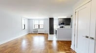 Located at 3 Davenport Ave in New Rochelle, NY, this one-bedroom, one-bathroom residence offers a well-designed layout across a single floor. The open-concept living and kitchen area is anchored by warm parquet hardwood flooring throughout, complemented by soft neutral wall tones that create a bright, welcoming atmosphere. Natural light filters in through multiple windows, enhancing the airy feel of the space. The modern kitchen is a standout feature, outfitted with sleek dark-wood cabinetry, crisp white quartz countertops, a peninsula with additional prep space, and a full suite of stainless steel appliances including a gas range, over-the-range microwave, refrigerator, and dishwasher. Marble-look tile flooring adds a refined touch to the kitchen area. The bedroom offers a comfortable footprint with a sliding-door closet, natural light from a window, and the same classic parquet flooring found throughout. The bathroom is elegantly finished with floor-to-ceiling marble-style wall tiles, a glass-enclosed walk-in shower with mosaic tile flooring, and a wall-mounted vanity. Additional closet space is available off the main living area, adding to the unit's practical storage capacity.