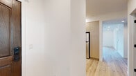 This single-floor residence at 1564 Hi Point St in Los Angeles offers a clean, modern aesthetic defined by light wood flooring and crisp white walls throughout. The open living area features recessed lighting and a sliding glass door that invites natural light while providing access to an outdoor space with neighborhood views.

The kitchen is thoughtfully designed with flat-front light wood cabinetry, white countertops, stainless steel appliances including a gas range and full-size refrigerator, a wall-mounted range hood, and a decorative blue-patterned tile backsplash that adds a distinctive visual accent.

The bedrooms are well-proportioned, bright spaces. One bedroom benefits from dual windows framing open sky views, while another features recessed lighting and access to an en-suite walk-in closet. The bathrooms are finished consistently, each featuring warm wood-toned vanities with white countertops, large-format white subway tile surrounding tub-shower combinations enclosed by matte black sliding glass doors, and wood-look flooring. Matte black hardware details appear throughout the unit, providing a cohesive contemporary contrast against the light palette.
