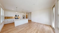 Located at 1005 Brentwood Dr in Davenport, FL, this single-story, 3-bedroom, 2-bathroom home offers a bright and modern living experience. The open-concept main living area seamlessly combines the kitchen, dining, and living spaces, all finished with light wood-look flooring that extends throughout the common areas. The kitchen is a standout, featuring a large center island with a quartz countertop and built-in sink, white shaker cabinetry, a warm wood-toned backsplash, stainless steel appliances, and globe pendant lights that add a contemporary touch. Natural light pours in through multiple windows fitted with blinds. A dedicated dining area connects to a patio via a sliding glass door, extending the living space outdoors. The hallway leads to three well-proportioned bedrooms, each with plush carpeting, ceiling fans, and windows with outdoor views. Six closets provide ample storage throughout. The bathrooms are finished with white vanities, quartz countertops, and wood-look tile flooring. A laundry room adds everyday convenience. The home's clean, neutral palette and modern finishes create a cohesive and welcoming atmosphere throughout.