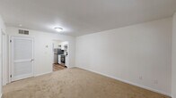 Located at 2057 Bethabara Rd in Winston-Salem, NC, this one-bedroom, one-bathroom unit offers a practical and well-organized single-floor layout. The entrance opens into a carpeted living room, bright with neutral white walls and a clean, open feel. A pass-through opening connects the living area directly to the kitchen, which features a galley-style design with white shaker cabinetry, granite-style countertops, wood-look vinyl flooring, and stainless steel appliances including a dishwasher, electric range, and refrigerator. A window at the end of the kitchen allows natural light to filter through. The bedroom is a comfortable, carpeted space with a window fitted with blinds that provides a view of surrounding greenery. A notable feature of the bedroom is access to a dedicated closet with built-in shelving. In total, the unit includes three closets, offering generous storage throughout. The entrance area also features a distinctive white vertical shiplap accent wall, adding a touch of character. The bathroom is appointed with a full-size soaking tub and shower combination, a toilet, and a window with blinds. Wood-look flooring extends through the bathroom and entrance areas, tying the space together cohesively.