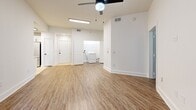 Located at 1925 Monroe Dr NE in Atlanta's vibrant Midtown area, this two-bedroom, one-bathroom unit offers a well-designed single-floor layout. The living area features warm hardwood-style vinyl flooring, crisp white walls, and a ceiling fan, creating a bright and airy atmosphere. An in-unit washer is conveniently tucked into the living space, adding everyday practicality. The kitchen is thoughtfully appointed with white shaker cabinetry featuring matte black hardware, light quartz countertops, a subway tile backsplash, and a full suite of stainless steel appliances including a refrigerator, range, microwave, and dishwasher — all set atop light tile flooring. Both bedrooms offer hardwood-style flooring and large windows that invite natural light and frame views of the surrounding greenery. The primary bedroom is generously sized and provides access to a dedicated closet. The bathroom is finished in a clean, modern style with white cabinetry, a quartz vanity, matte black fixtures, tile flooring, and a tiled shower surround. A hallway connects the main living areas, and two closets provide ample storage throughout the unit. The overall aesthetic is clean, contemporary, and move-in ready.