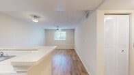 Located at 2351 Northwest 119th Street in Miami, FL, this single-floor, 2-bedroom, 1-bathroom unit offers a practical and efficient layout. Wood-style flooring runs throughout the home, lending a warm, cohesive feel to every room.

The combined kitchen and living area anchors the unit. The kitchen features warm-toned wood cabinetry, light countertops, a breakfast bar peninsula, and black appliances including a range, refrigerator, and dishwasher. A stainless steel sink and ample cabinet storage complete the functional space. The adjoining living area benefits from natural light through a window and includes a ceiling fan for year-round comfort.

Both bedrooms continue the wood-style flooring and are finished in neutral tones. Each room includes a ceiling fan and window with blinds that allow natural light and outdoor views. The primary bedroom offers a built-in louvered closet, while the second bedroom provides a similarly bright, open feel.

The bathroom is clean and simply designed, featuring a full tub-shower combination with white tile surround, grab bars, and wood-style flooring. Textured ceilings are present in several rooms, adding a subtle architectural detail consistent throughout the home.