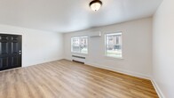 Located at 1823 Griswold Dr in Fort Wayne, Indiana, this efficiently designed one-bedroom, one-bathroom unit makes excellent use of its cozy footprint. Throughout the space, light wood-look flooring and crisp white walls create a clean, bright atmosphere that feels fresh and well-maintained.

The living room offers a welcoming area filled with natural light from dual windows that frame views of the surrounding neighborhood. A wall-mounted mini-split unit and baseboard heating ensure year-round comfort. The space flows naturally into the galley-style kitchen, which features white cabinetry, dark hardware, granite-look countertops, and a stainless steel sink beneath a window that brings in additional natural light.

The bedroom is a comfortable, well-proportioned retreat equipped with a ceiling fan with light fixture, a closet with bi-fold doors, and a window overlooking greenery. Baseboard heating keeps the room warm during cooler months.

The bathroom is a standout feature, finished with large-format marble-look wall tiles surrounding a soaking tub and shower combination. Matte black fixtures add a modern contrast to the light tile, while a frosted window provides privacy and ventilation.

A hallway connects the rooms efficiently, completing this tidy, move-in-ready layout ideal for those seeking a streamlined living space in Fort Wayne.