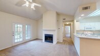 Located at 196 Jeff Rd NW in Huntsville, Alabama, this single-story, 2-bedroom, 3-bathroom home offers a well-designed layout with a comfortable and functional living environment. The living room is a standout space, featuring soaring vaulted ceilings, a classic wood-burning fireplace with a white mantel, and French doors that invite natural light and outdoor views. Ceiling fans are present throughout the home, adding both style and practicality. The kitchen is bright and well-appointed, featuring white cabinetry, ample counter space with a double sink, tile flooring, and a full suite of appliances including a range, microwave, dishwasher, and refrigerator. A pass-through connects the kitchen to the living area, creating an open, communicative floor plan. The bedrooms are carpeted and generously sized, each offering ceiling fans and windows with natural light. The primary bedroom includes its own dedicated bathroom with a white vanity, large mirror, and warm lighting. Both closets are walk-in style, equipped with wire shelving systems for organized storage. Hardwood-style flooring runs through the hallways and bathrooms, complementing the neutral, warm color palette found throughout the home. With two hallways connecting the spaces and three full bathrooms, this home provides both comfort and convenience.