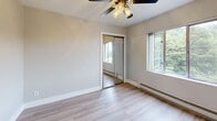 Located at 1969 SW Park Ave in Portland, Oregon, this one-bedroom, one-bathroom unit offers a thoughtfully arranged floor plan that maximizes every square foot of its compact footprint. The open-concept main living area seamlessly combines the dining room, kitchen, and living room into a single, cohesive space. The kitchen is equipped with stainless steel appliances, including a gas range and refrigerator, and features a peninsula counter that provides both workspace and a natural dividing element between cooking and living areas. Light-toned hardwood-style flooring runs throughout the unit, contributing to a bright and airy atmosphere. The bedroom is a comfortable retreat, benefiting from natural light through windows with views of surrounding greenery, a ceiling fan with integrated lighting, a closet, and baseboard heating. The bathroom is clean and functional, featuring a pedestal sink, a mirrored medicine cabinet, and a shower-tub combination. Additional storage is provided through two closets and a dedicated pantry. The unit also includes a welcoming entrance. Neutral wall tones and white trim throughout create a clean, cohesive aesthetic well-suited to a variety of furnishing styles.