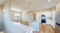 This thoughtfully designed home offers a seamless blend of modern finishes and functional living spaces across its layout. The heart of the home is an open-concept kitchen and living area, where light hardwood-style flooring flows throughout, creating a bright and cohesive atmosphere. The kitchen is well-equipped with white shaker cabinetry, granite countertops, a subway tile backsplash, and a full suite of stainless steel appliances including a range, microwave, and a large refrigerator. A central island with an undermount sink and elegant pendant lighting serves as both a prep space and a natural gathering point.

The living area benefits from abundant natural light through multiple windows dressed with blinds, and a ceiling fan adds comfort to the space. Bedrooms feature plush carpeting and generous windows that invite natural light, offering a calm and restful environment. The bathrooms are finished with granite-topped white vanities and wood-look flooring, with one full bath featuring a tub-shower combination with clean white tile surround. A carpeted staircase with a white handrail connects the levels, topped by a window that bathes the passage in natural light. Throughout the home, neutral tones and clean lines create a fresh, move-in-ready aesthetic.