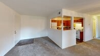 This single-floor residence offers a functional and comfortable layout across several well-defined living spaces. The living room is generously sized, featuring wall-to-wall carpeting, a ceiling fan with integrated lighting, and a bank of large windows and a sliding glass door that invite abundant natural light and provide outdoor views. The space connects visually to the kitchen through a half-wall pass-through, creating an open and connected feel between the two areas.

The kitchen is fully equipped with warm-toned wood cabinetry extending to the ceiling for ample storage, dark stone-look countertops, and white appliances including a gas range, dishwasher, and refrigerator. A central ceiling light fixture and durable tile flooring complete the functional kitchen environment.

The bedrooms are carpeted and bright, with multiple windows allowing natural light to filter in. The primary bedroom stands out with two full-width closets featuring built-in shelving, providing substantial storage capacity. The additional bedroom is cozy and well-lit, with a window overlooking greenery outside.

The bathroom is equipped with a full tub and shower combination, a toilet, and vanity, finished with tile flooring for a clean, practical aesthetic. Overall, the residence offers a straightforward, livable layout well-suited for everyday comfort.