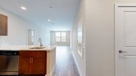 This 1,040-square-foot, three-bedroom, two-bathroom apartment is located at 751 Vandenburg Rd, Apt 1305, in King of Prussia, PA. The open-concept kitchen and living area serves as the heart of the home, featuring warm wood cabinetry, white quartz countertops, a subway tile backsplash, and a full suite of stainless steel appliances including a gas range, microwave, refrigerator, and dishwasher. A peninsula island provides additional prep and dining space. Hardwood-style flooring flows throughout the entire unit, complementing the neutral, light-toned walls. The primary bedroom spans 210 square feet and includes direct access to an outdoor balcony, multiple windows for natural light, and a spacious walk-in closet with wire shelving systems. The additional bedrooms are well-sized, each with windows offering exterior views and ceiling fans for added comfort. Two full bathrooms feature rich wood vanities, white countertops, and light tile flooring. Both bathrooms include tub-shower combinations. Two dedicated closets with wire rack shelving provide generous storage throughout the unit. Recessed lighting and clean architectural lines give the apartment a contemporary, move-in-ready feel.