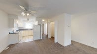 Located at 33 Pope Way in South Charleston, West Virginia, this multi-floor home offers a well-organized layout spread across three levels. The kitchen is designed in a U-shaped configuration, outfitted with white cabinetry featuring gold hardware, dark countertops, tile flooring, and a full suite of white appliances including a refrigerator, electric range, dishwasher, and microwave. A window above the sink allows natural light to filter into the space. Adjacent to the kitchen, the main living area features neutral carpet, ceiling fans for climate comfort, and open access to closet storage. Bathrooms throughout the home are finished with tile flooring and white fixtures; one includes a tub-shower combination, while another features a pedestal sink and compact layout. Ample closet space is present, including a walk-in style closet with wire shelving. A standout feature is the enclosed porch, lined with large windows that frame views of the surrounding greenery and gently sloping landscape, creating a bright and tranquil retreat. Carpeted bedrooms are well-proportioned with ceiling fans and clean white walls. The home also includes an attached garage with an automatic opener, offering secure parking and additional storage. The overall aesthetic is clean, neutral, and functional throughout.