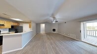 This well-appointed 3-bedroom, 2-bathroom single-floor home in Okemos, Michigan offers a thoughtfully designed layout with comfortable living spaces throughout. The expansive living room is a standout feature, boasting vaulted ceilings, a ceiling fan, and a cozy fireplace as the focal point. Plush carpeting runs throughout the living area, and a sliding glass door opens to a private outdoor balcony, bringing in natural light and outdoor views. The kitchen is galley-style with light wood cabinetry, wood-look flooring, a skylight panel, and black appliances including a refrigerator and range. A pass-through counter connects the kitchen to the living area, enhancing the open feel. The three bedrooms are carpeted and well-sized, with the primary bedroom offering generous space. Each bedroom benefits from natural light, with windows overlooking the surrounding area. Three closets — including a walk-in style with a full hanging rod — provide ample storage. The two bathrooms are clean and functional, with one featuring a full tub-shower combo and wood-look flooring. Three hallways connect the rooms efficiently, creating a smooth and practical flow throughout the home.
