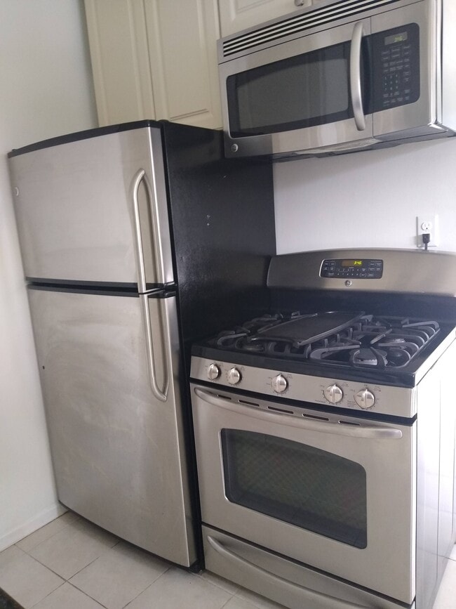 Stainless Steel GE appliances: refrigerator, stove, microwave. - 4127 Everts St