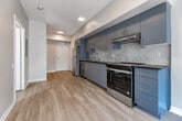 Located at 50 Portland Street in Toronto's vibrant King West neighbourhood, this one-bedroom, one-bathroom unit offers a well-designed open-concept layout with clean, modern finishes throughout. Light-toned laminate flooring runs continuously across the living spaces, enhancing the sense of openness and reflecting the abundant natural light that pours in through the large floor-to-ceiling windows along the living area's exterior wall.

The galley-style kitchen is outfitted with sleek grey cabinetry accented by gold hardware, a white subway tile backsplash, a stainless steel sink, and a full suite of appliances including a refrigerator, stove, and dishwasher. The kitchen flows directly into the open living area, creating a practical and cohesive space ideal for both everyday living and entertaining.

The bedroom is a calm, neutral space with warm greige walls, light hardwood-style flooring, and a generous window that draws in natural daylight and urban views. The four-piece bathroom features a soaker tub with a full-height marble-style tile surround, a glass shower screen, a white vanity with under-mount sink, and recessed lighting, all contributing to a clean and polished aesthetic. The textured ceiling throughout the unit adds a subtle architectural detail. This unit offers a compact yet functional layout in one of Toronto's most sought-after neighbourhoods.