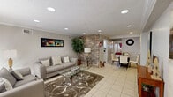 This 530 square foot apartment in Houston, Texas offers a thoughtfully designed living space that maximizes functionality and style. The single-floor layout encompasses one bedroom, one bathroom, a living room, kitchen, closet, and hallway. The primary bedroom, measuring 140 square feet, features a comfortable queen-sized bed, a ceiling fan for air circulation, and vibrant red accents in the curtains and bedding.

The living area boasts recessed lighting, crown molding, and a combination of tile flooring and area rugs. Two plush gray sofas provide ample seating, while a glass coffee table adds a touch of elegance. A striking colorful abstract artwork adorns the wall, complementing the neutral tones of the room. Large windows allow natural light to flood the space, and a tall indoor plant adds a refreshing touch of greenery.

The kitchen, though compact, is efficiently designed with white cabinetry, light-colored countertops, and essential appliances. Built-in shelving offers additional storage and display space for decorative items. The bathroom features a modern design with a patterned shower curtain in complementary colors.

The apartment's entrance area showcases a textured accent wall and a stylish console table, creating an inviting first impression. Throughout the space, the color scheme of whites, grays, and pops of red creates a cohesive and contemporary ambiance. Despite its modest size, this apartment offers a well-planned layout that feels spacious and inviting, perfect for comfortable city living.