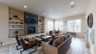 Located at 802 South Garfield Road in Airway Heights, Washington, this single-story community amenity space is thoughtfully designed to offer residents a variety of shared gathering and recreational areas. The welcoming lounge area features warm neutral tones, light wood-style flooring, comfortable seating, and a small kitchenette with white cabinetry — ideal for casual socializing. A pass-through window connects this space to a reception or office area, adding a practical and open feel. Adjacent to the lounge, a bright dining nook is bathed in natural light from large windows fitted with white blinds, offering views of the surrounding neighborhood and space for small group gatherings. A spacious common room serves as the centerpiece of the facility, anchored by a sleek dark tile fireplace wall with built-in shelving and a wall-mounted TV. Comfortable furnishings and ample natural light from multiple windows create an inviting atmosphere. The well-equipped fitness center features rubber flooring, vaulted ceilings, cardio machines, a cable machine, stationary bike, weight bench, and a wall-mounted TV. A private cinema room rounds out the amenities, complete with a large sectional sofa, elevated bar-style seating, surround sound, and classic movie-themed décor. The full kitchen, with stainless steel appliances, white cabinetry, and track lighting, supports larger events and gatherings.