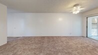 Located at 2075 N Highland Ave in Clearwater, FL, this single-floor residence offers a practical and comfortable layout with two bedrooms, two bathrooms, and a thoughtfully arranged floor plan. The combined living and dining area serves as the heart of the home, featuring plush carpeting, a textured ceiling, a ceiling fan, and wide sliding glass doors that invite abundant natural light and provide direct access to an outdoor latticed patio area. A pendant light fixture distinguishes the dining portion of this open shared space. The kitchen is equipped with white cabinetry, a double-basin sink, laminate countertops, and hardwood-style flooring, with a large window offering pleasant outdoor views. The spacious primary bedroom benefits from multiple windows on two walls, flooding the room with natural light and views of surrounding greenery. The second bedroom also features carpet, a ceiling fan, and windows that bring in natural light. Four closets throughout the home provide generous storage. The two bathrooms are clean and functional — one featuring a walk-in shower and the other a full soaking tub — both with hardwood-style flooring and crisp white finishes. A hallway connects the bedrooms and bathrooms, completing this well-organized and move-in ready layout.
