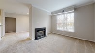 Located at 50 Turnberry Ct in Bear, Delaware, this single-floor residence offers a well-designed layout with a cohesive blend of comfort and modern updates throughout. The open living area is a standout space, featuring plush neutral carpeting, crown molding, and a black granite fireplace surround that serves as a focal point. A large window fills the room with natural light and offers views of surrounding greenery, creating a warm and inviting ambiance. The living space flows openly toward the kitchen and additional rooms, enhancing the sense of connectivity throughout the home. The kitchen is well-appointed with crisp white cabinetry, dark granite countertops, a white subway tile backsplash, and stainless steel appliances including a refrigerator, range, and over-the-range microwave. Light wood-look flooring adds a contemporary touch to this functional space. The bedroom features soft carpeting, a generous window with outdoor views, and a clean, neutral palette. The bathroom is neatly finished with tile flooring, a full tub-shower combination, and white fixtures. Additional storage is provided by closet doors visible from the main living area, and the overall design maintains a bright, move-in-ready feel throughout.