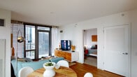 Located on the 32nd floor of 345 E Wacker Drive in the heart of Chicago, this thoughtfully designed high-rise residence offers a compelling blend of modern aesthetics and urban convenience. Floor-to-ceiling windows throughout the unit flood every room with natural light while framing sweeping views of the Chicago skyline and the Chicago River below.

The open-concept living and dining area features warm hardwood flooring and a functional, stylish layout. A round wood dining table with contemporary white chairs anchors the dining space, while the living area accommodates a comfortable seating arrangement complemented by an arc floor lamp and colorful wall art. The seamless flow between these spaces makes the unit feel expansive and inviting.

The galley-style kitchen is outfitted with dark cabinetry, stainless steel appliances including a gas range and full-size refrigerator, and light countertops. A large window provides a dramatic city backdrop, making even everyday tasks feel elevated.

The bedroom is a tranquil retreat featuring sheer curtains, access to city views, and clean white walls accented by a large textured wall piece above the bed. The bathroom offers a clean, contemporary design with dark vanity cabinetry, a large mirror, and tile flooring. This residence delivers an exceptional Chicago living experience with style and functionality throughout.